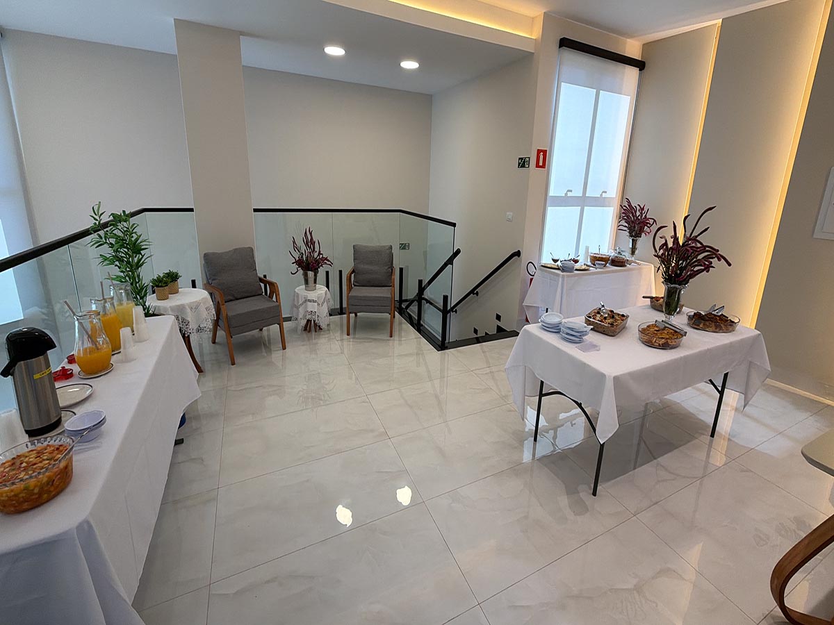 Área de coffee break com mesas de alimentos e bebidas