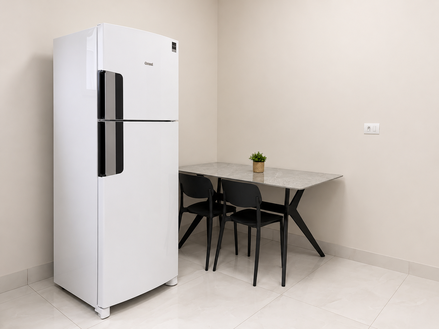 Cozinha com geladeira, mesa e cadeiras